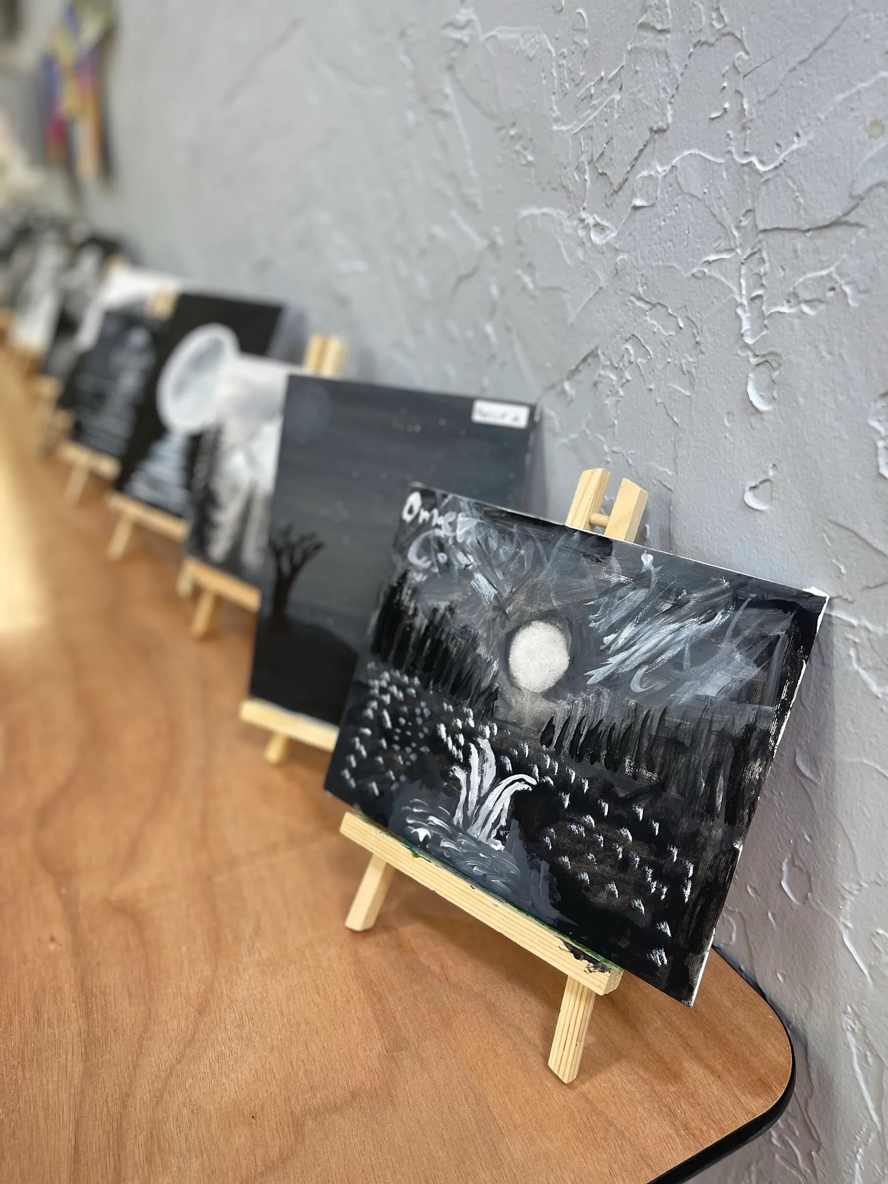 Student black-and-white canvas paintings on easels