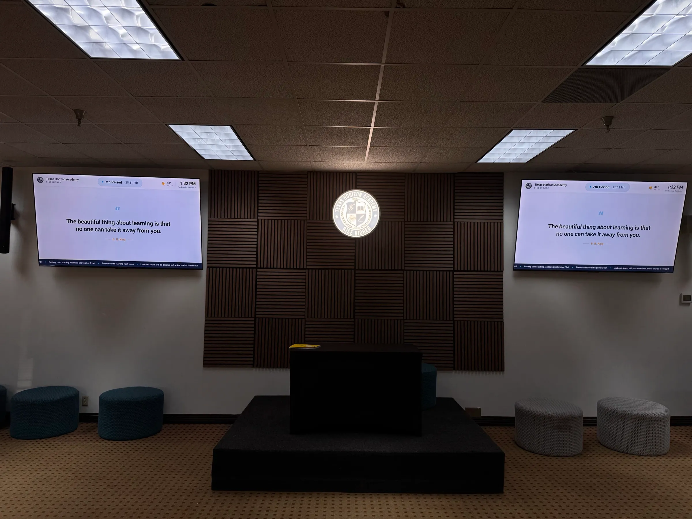 Assembly area with a stage, school seal and screens