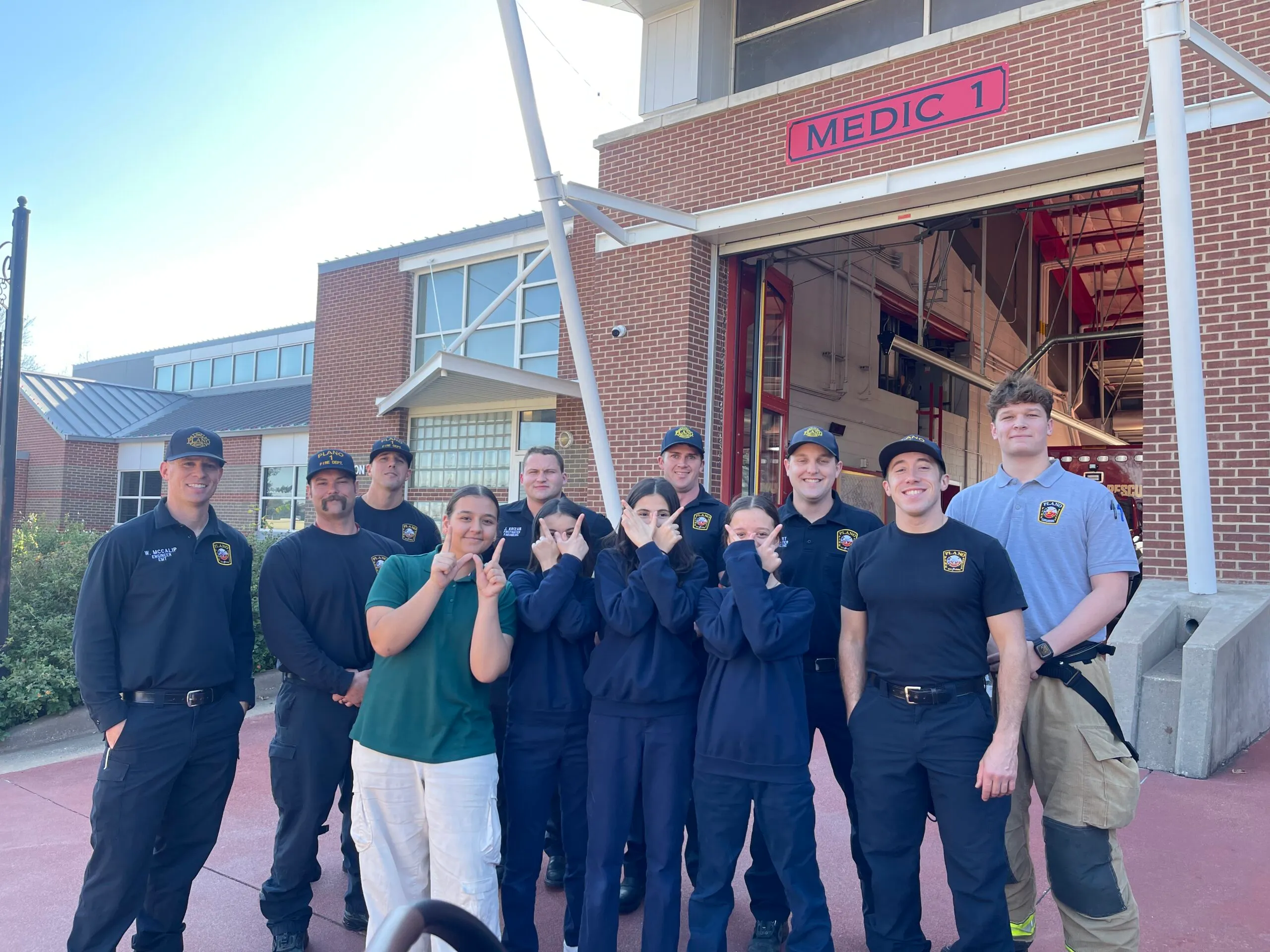 Students with firefighters at a fire station