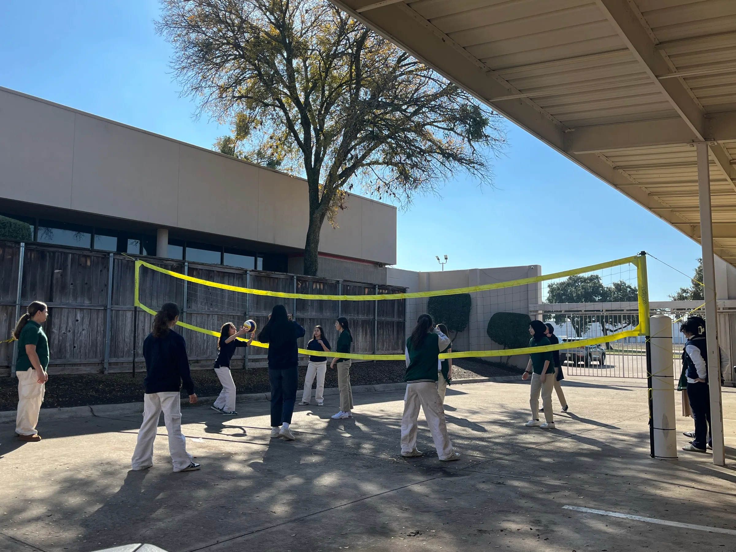 Students playing volleyball outdoors at school